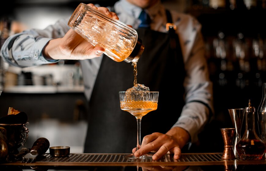 Barman pouring cocktail in smart bar