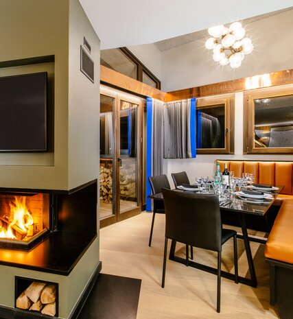 Contemporary ski apartment Chalet Sakami with leather banquette seating area and log burning fire 