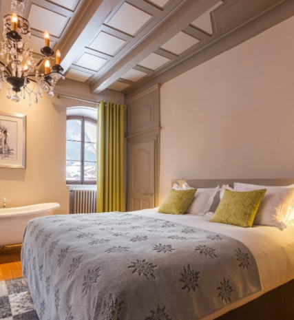 Elegant bedroom with chandelier and freestanding bath