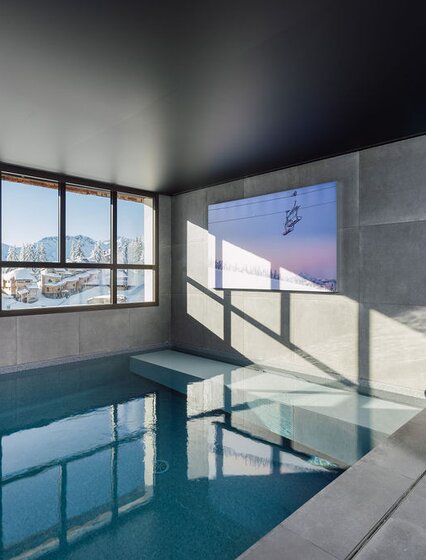 Indoor swimming pool with view of snowy Avoriaz in Chalet Ipaka