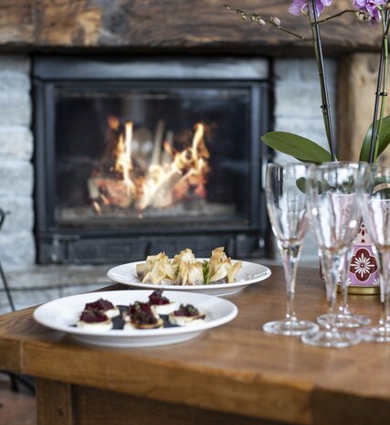 Canapés, champagne and glasses laid out in front of roaring fire