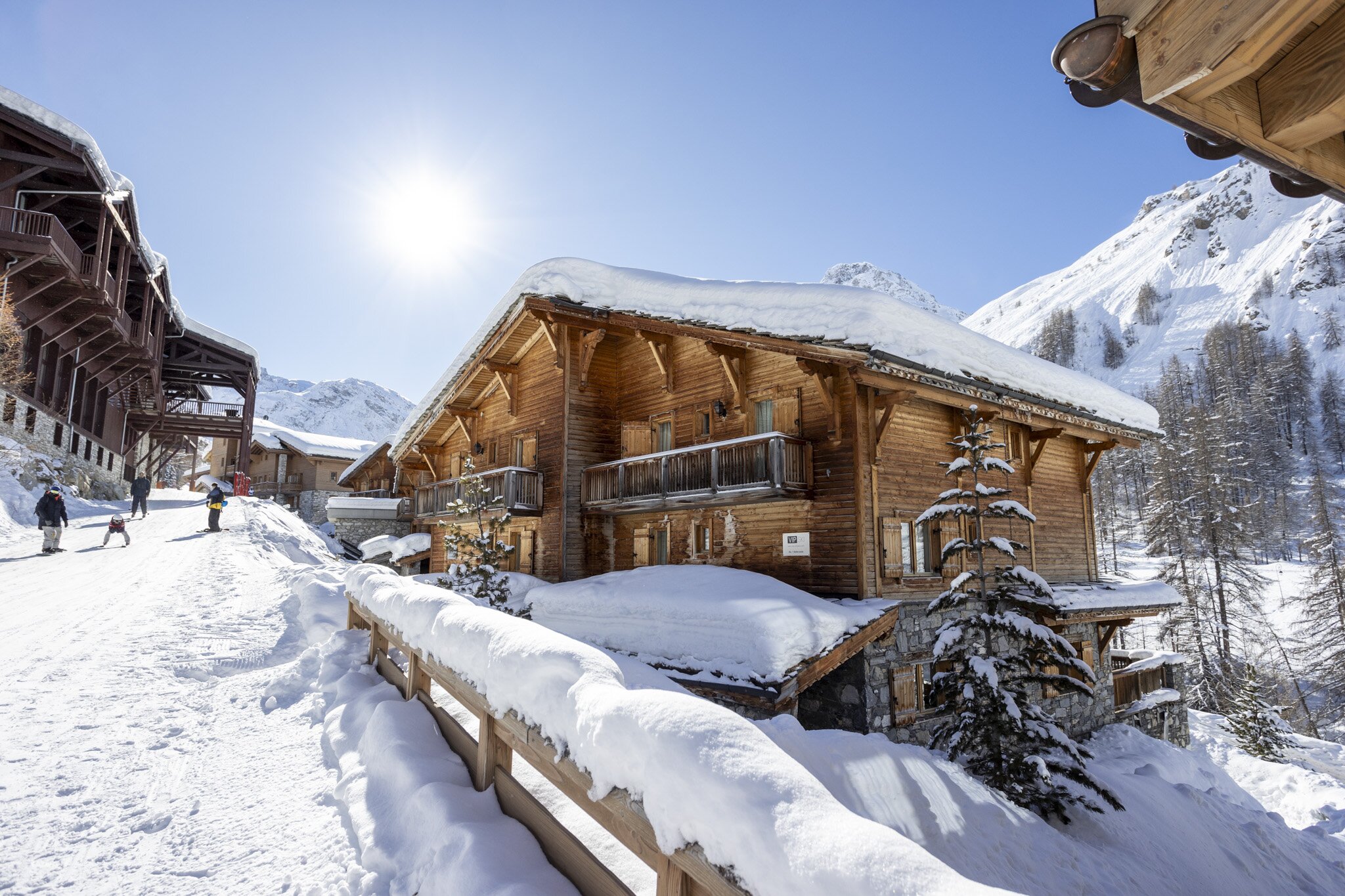 VIP SKI chalet Bellevarde in Val d'Isere next to snowy piste with skiers and snowboarders