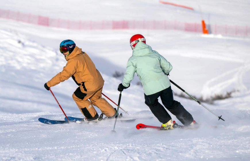 Female skier following New Generation ski instructor doing parallel turns