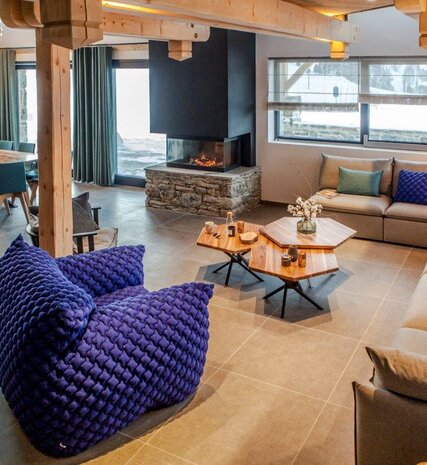 Contemporary living area with sofa and tiled floors and woodburning stove in Chalet 21Forty in Les Arcs