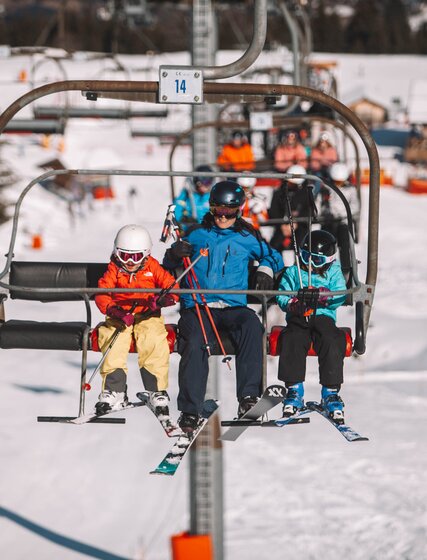 Father and two young children on chairlift