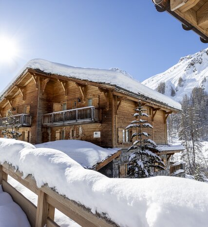 Exterior of traditional wooden ski chalet covered in snow in Val d'Isere