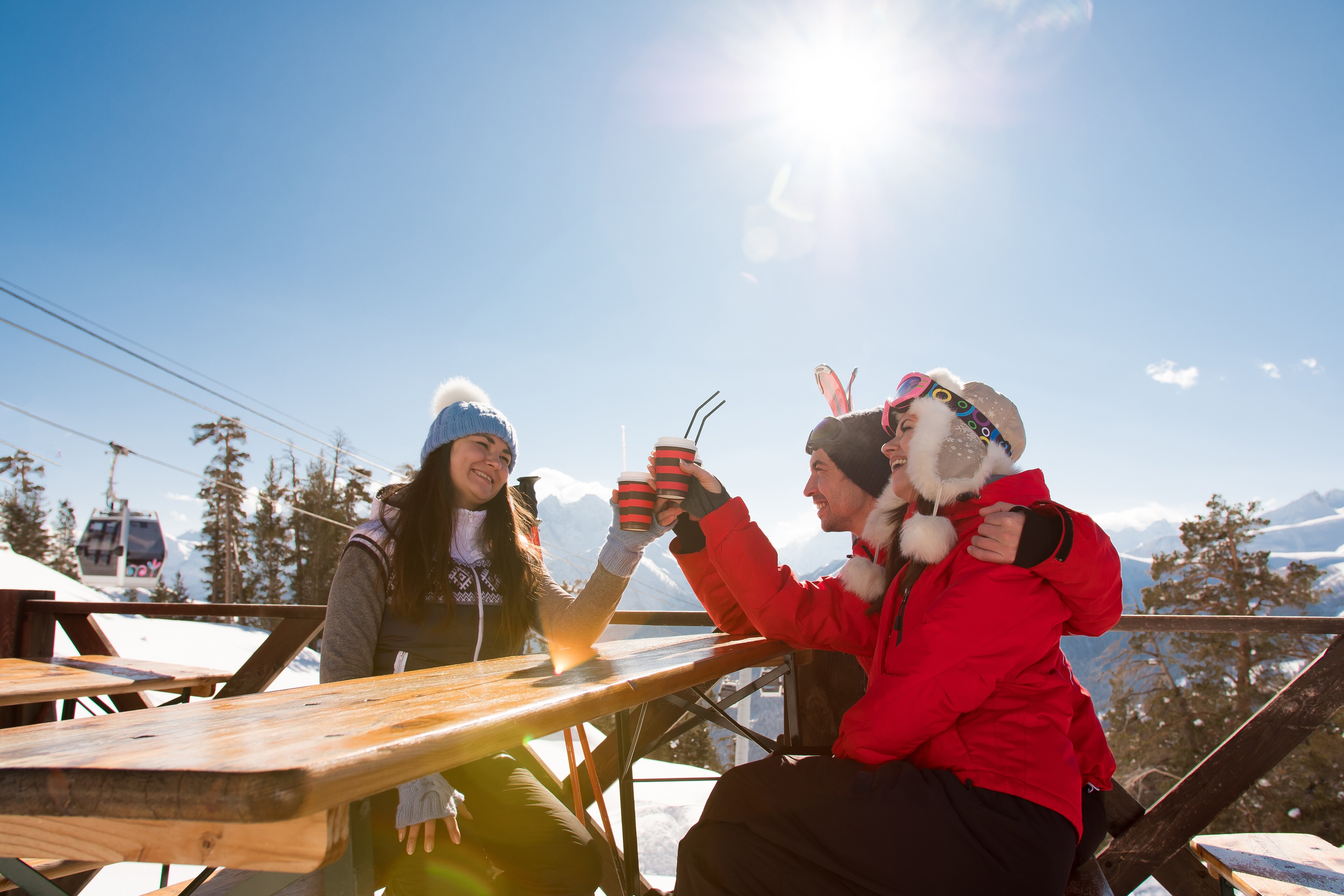 Smiling friends drinking outside mountain bar