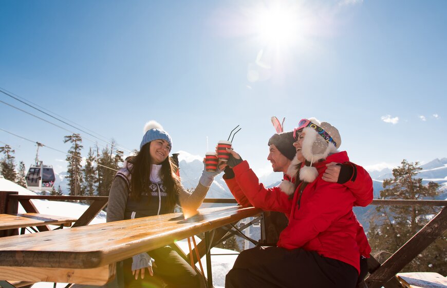 Smiling friends drinking outside mountain bar