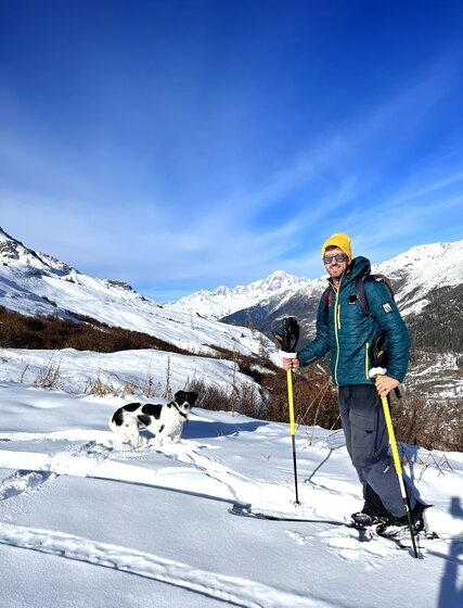 Ski instructor Terry ski touring with black and white dog