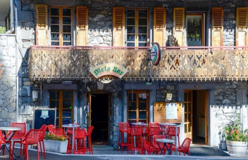 Exterior of Dxie Bar in Morzine with red chairs and tables outside