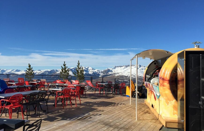 Sunny restaurant terrace with views of snowy mountains