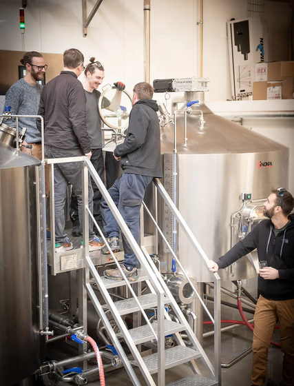 Four men being shown around brewery