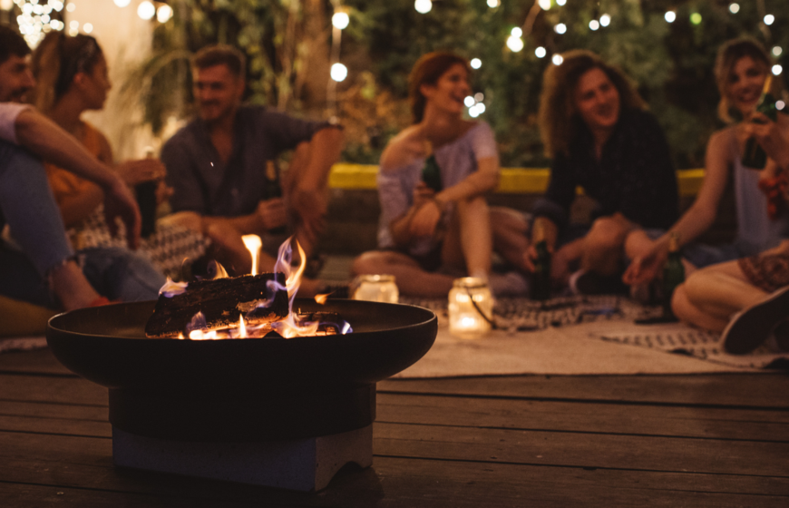 Friends sitting around firepit in the evening