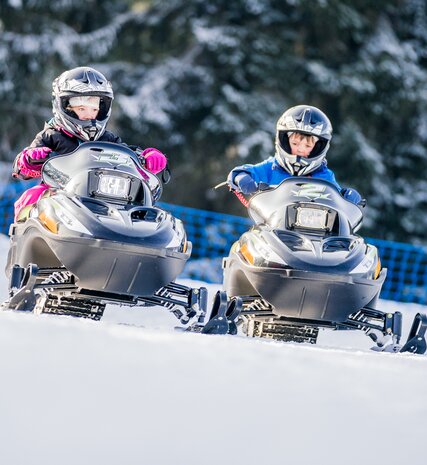 Two children on small electric skidoos