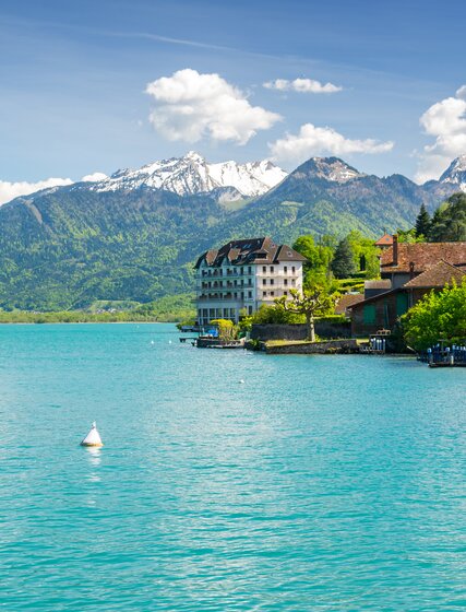 Lake Annecy with turquoise water and snow-capped mountains in the background