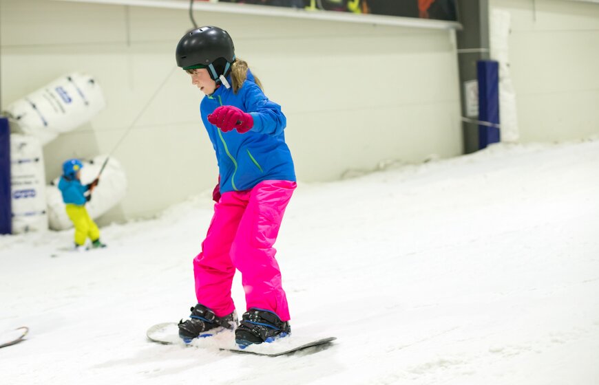 Young girls snowboarding in indoor ski centre