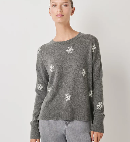 Woman wearing grey cashmere round neck jumper with white snowflakes from The White Company