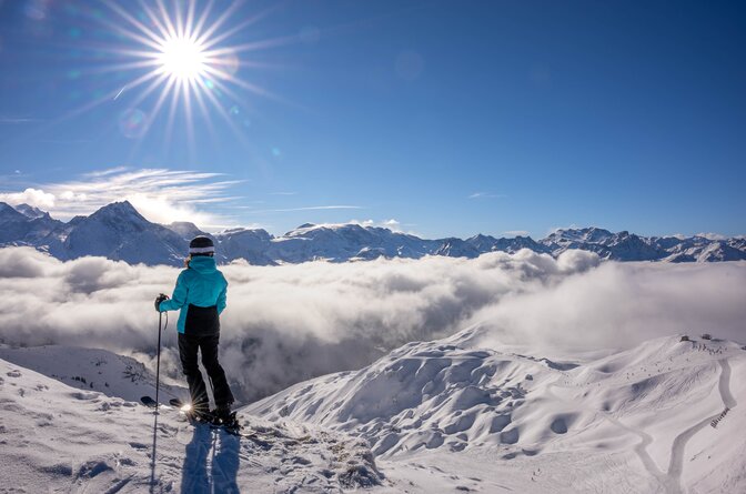 Female skier looking out over slopes of La Plagne on sunny day