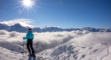 Female skier looking out over slopes of La Plagne on sunny day