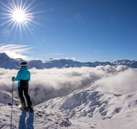 Female skier looking out over slopes of La Plagne on sunny day