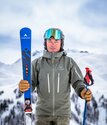 Ski instructor Mark Jones smiling at camera and holding skis and poles