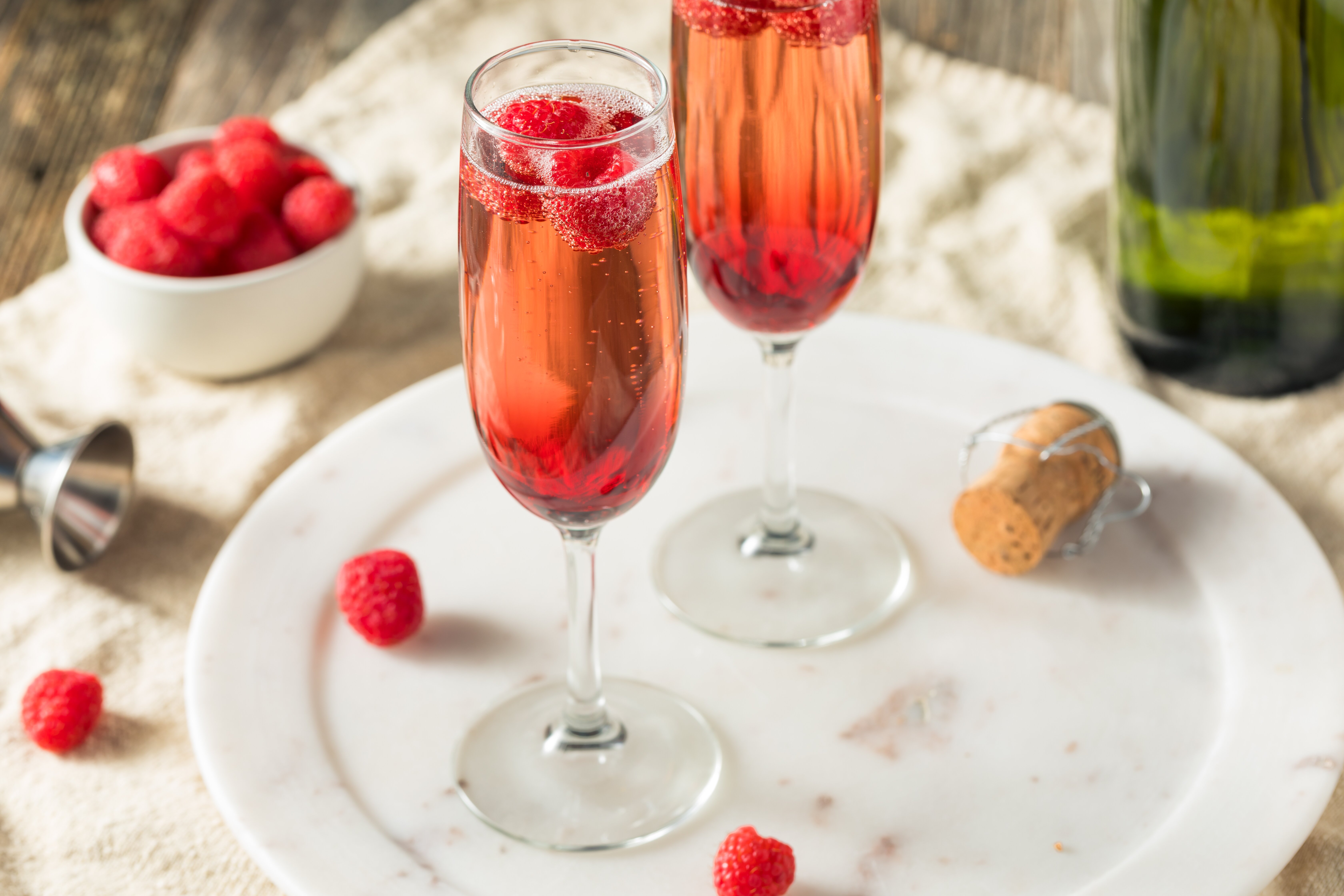 Two glasses of kir royale with some raspberries