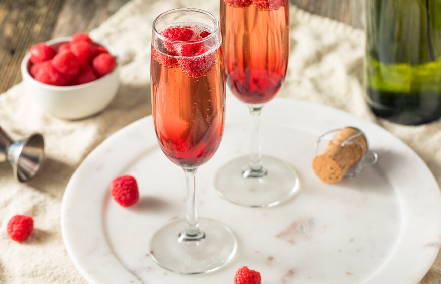 Two glasses of kir royale with some raspberries 