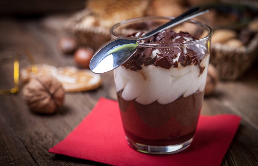 Chocolate dessert in small glass with cream and grated chocolate on the top