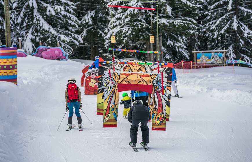 Families skiing on Indian-themed ski trail in Les Gets