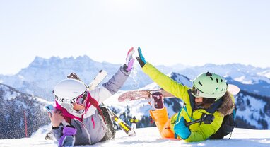 two female friends in the snow with ski equipment