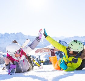 two female friends in the snow with ski equipment