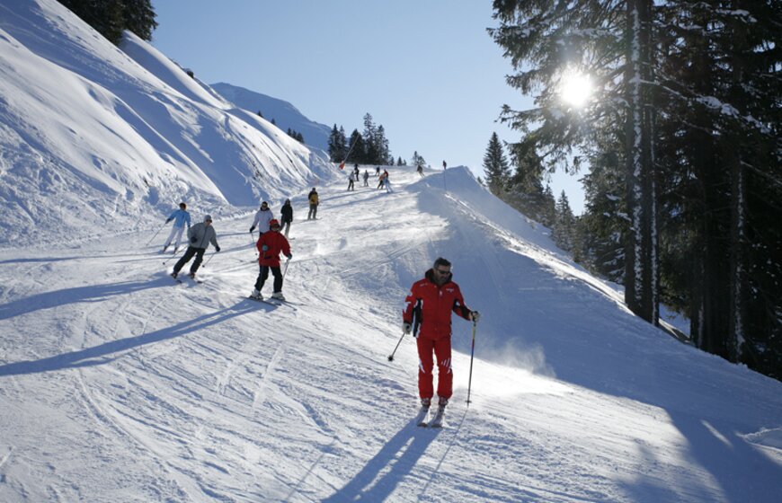 Beginner skiers following ski instructor down slope in Avoriaz