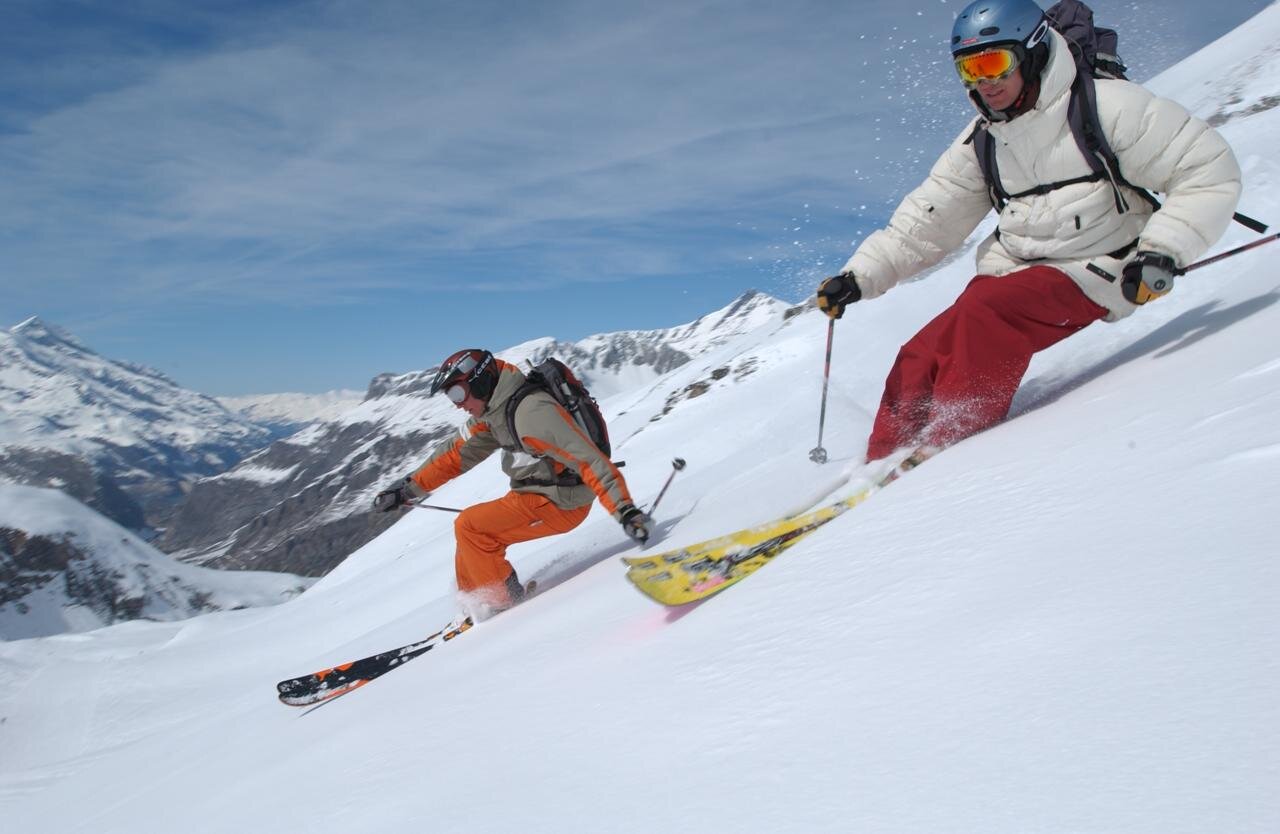 Two male skiers skiing powder in Val d'Isere