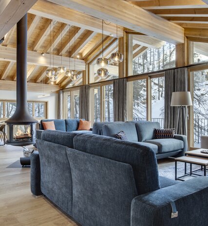 Contemporary living area with sofa and tiled floors and woodburning stove in No 7 CLUB Bellevarde in Val d'Isere