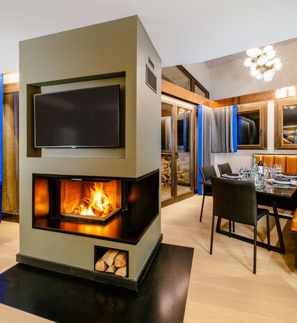 Log burning fire in centre of living area in contemporary Chalet Sakami in Avoriaz