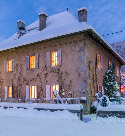 The Manoir chalet by VIP SKI in Morzine in the evening with the lights of Morzine in the background