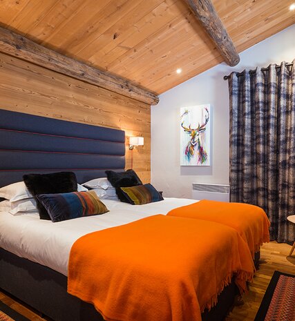 Double bed with orange throws at foot of bed in No 3&4 CLUB Bellevarde in Val d'Isere